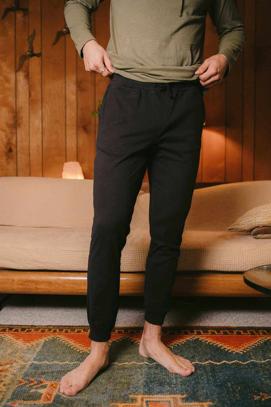Hemp Jogger in black with a smooth fabric, elastic drawstring waist, side pockets, and tapered cuffed ankles