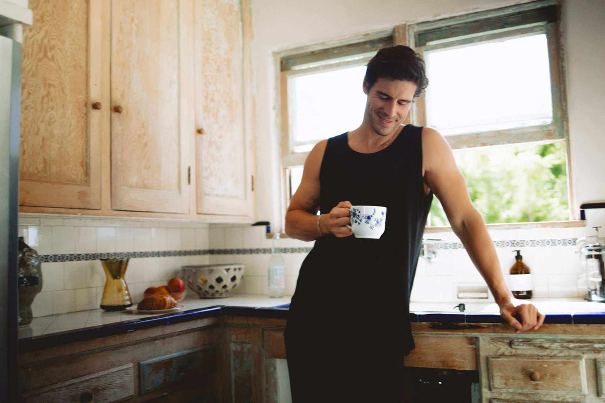 Hemp Tank Top in black sleeveless jersey with a classic muscle cut, worn by a man in a kitchen