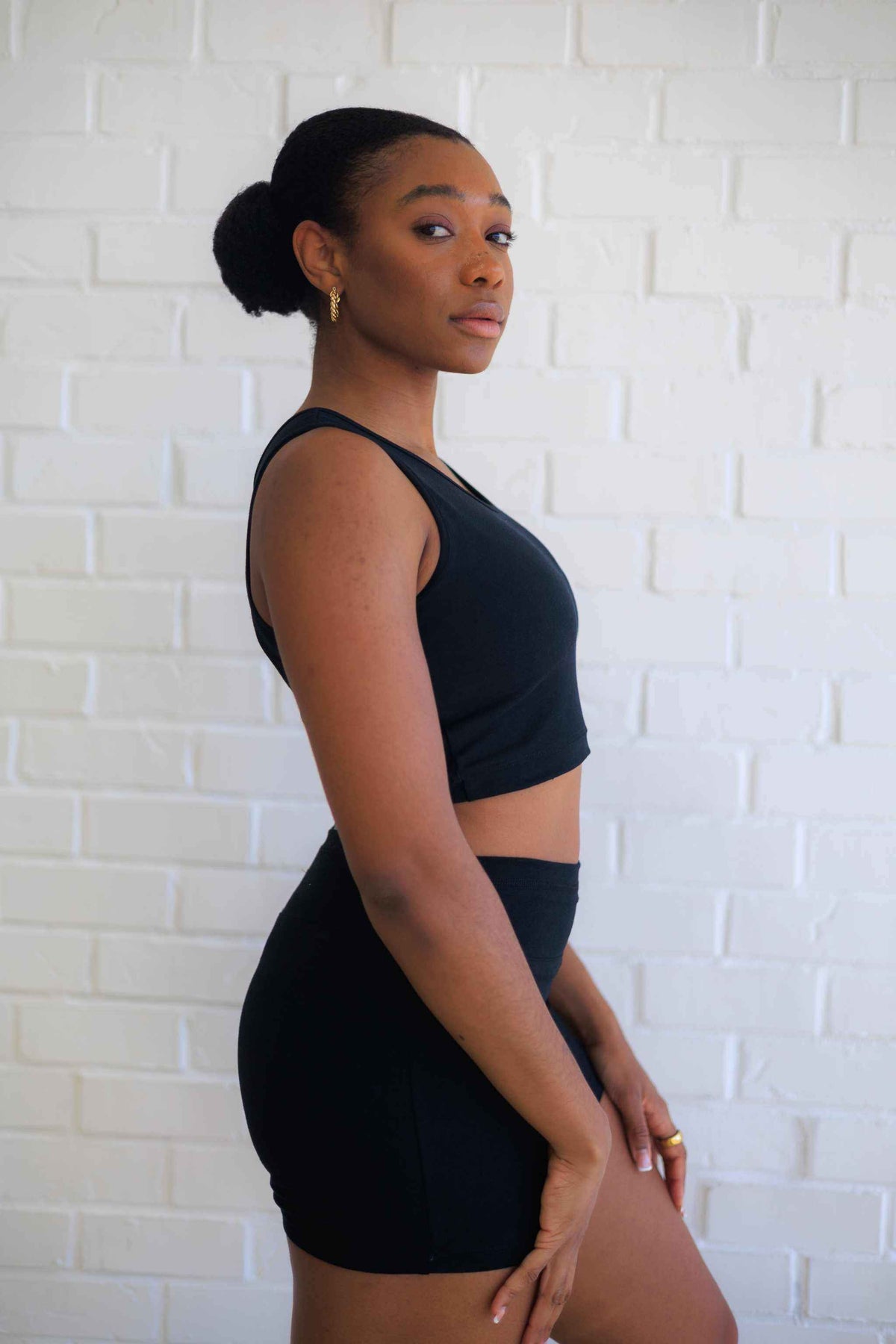 Women's Yoga Shorts in solid black with a fitted high-rise waistband, shown with a matching black sleeveless crop top