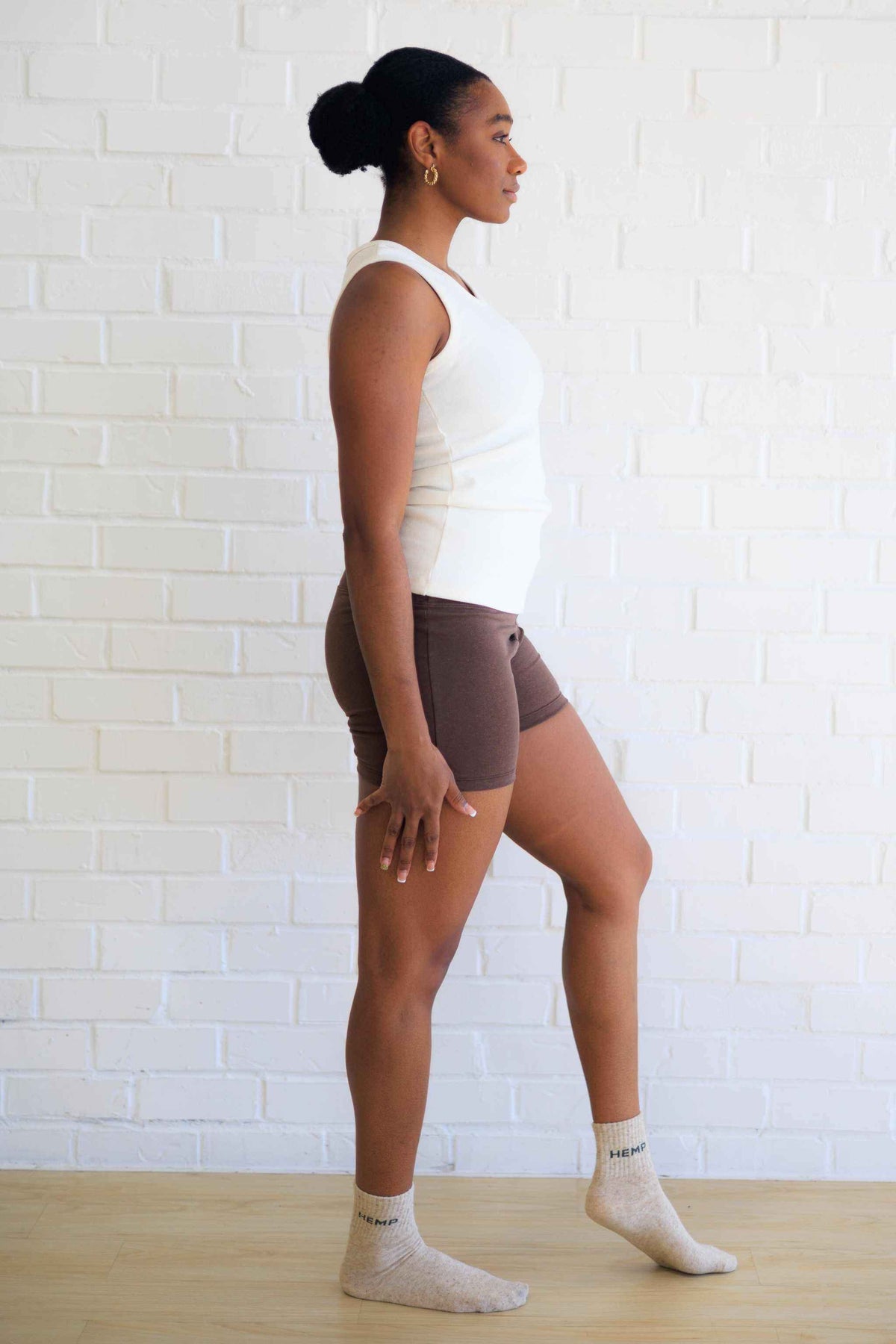 Women's Yoga Shorts in chocolate brown, fitted with a wide waistband and short inseam, paired with a white top