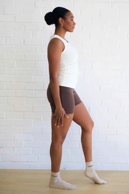 Women's Yoga Shorts in chocolate brown, fitted with a wide waistband and short inseam, paired with a white top