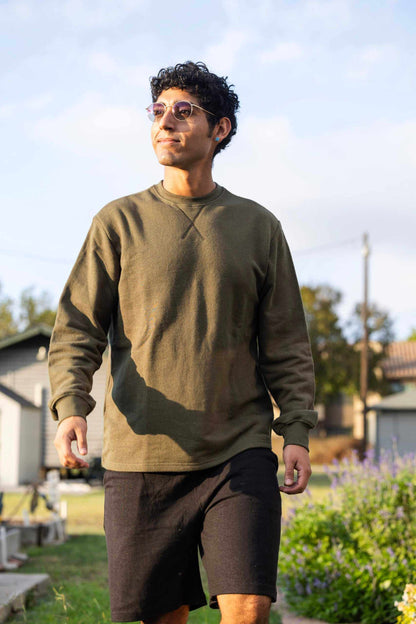 Man wearing olive hemp terry sweatshirt outdoors