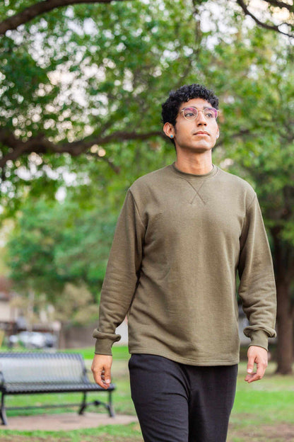 Unisex olive hemp terry sweatshirt worn outdoors