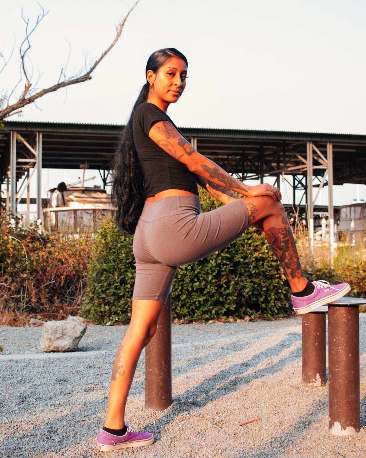 Woman wearing gray women's hemp bike shorts stretching outdoors