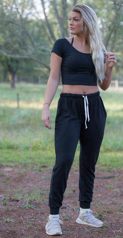 Woman wearing black hemp joggers with drawstring waist and tapered leg outdoors
